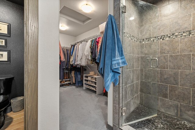 6315 Dunsmore Rd, Rapid City, SD 57702 - bathroom with a stall shower, a spacious closet, and a textured wall