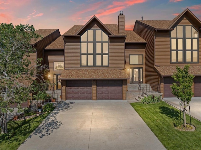 340 Fairway Dr, Spearfish, SD 57783 - view of front facade featuring an attached garage, concrete driveway, roof with shingles, a chimney, and a front lawn
