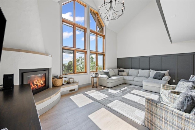340 Fairway Dr, Spearfish, SD 57783 - living area featuring high vaulted ceiling, a chandelier, a fireplace, and wood finished floors