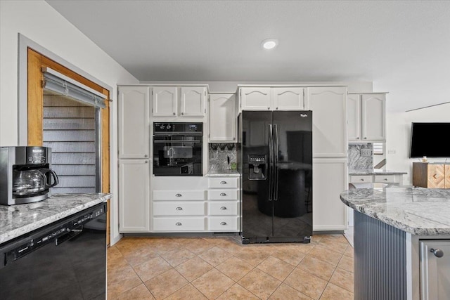 340 Fairway Dr, Spearfish, SD 57783 - kitchen with black appliances, white cabinetry, light stone counters, and light tile patterned floors