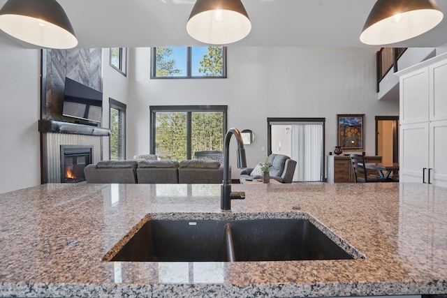 21332 Trailside Rd, Lead, SD 57754 - kitchen featuring a high ceiling, open floor plan, stone counters, and a fireplace