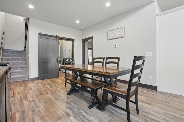 21332 Trailside Rd, Lead, SD 57754 - dining space featuring a barn door, light wood-style floors, recessed lighting, and stairway