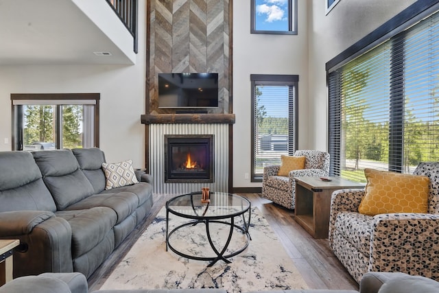 21332 Trailside Rd, Lead, SD 57754 - living room with wood finished floors, a large fireplace, and a towering ceiling