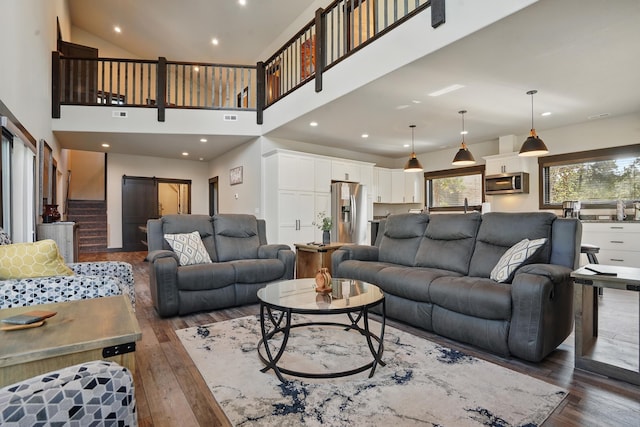 21332 Trailside Rd, Lead, SD 57754 - living room with a barn door, dark wood-style floors, and a towering ceiling