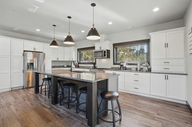 21332 Trailside Rd, Lead, SD 57754 - kitchen with stainless steel appliances, recessed lighting, an island with sink, a breakfast bar, and white cabinetry