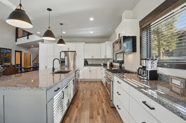 21332 Trailside Rd, Lead, SD 57754 - kitchen with appliances with stainless steel finishes, white cabinets, wood finished floors, pendant lighting, and recessed lighting