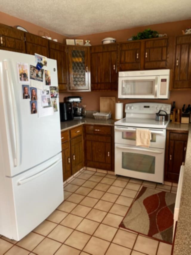 603 E 1st St, Buffalo, SD 57720 - kitchen with white appliances, a textured ceiling, light tile patterned floors, and light countertops