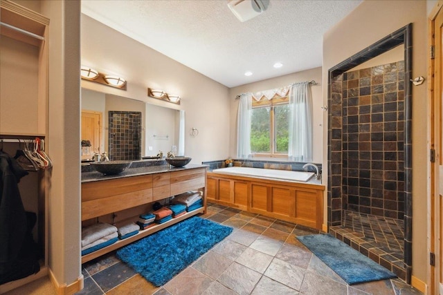2040 Aster Rd, Spearfish, SD 57783 - full bathroom with a bath, vanity, a textured ceiling, a tile shower, and stone tile floors
