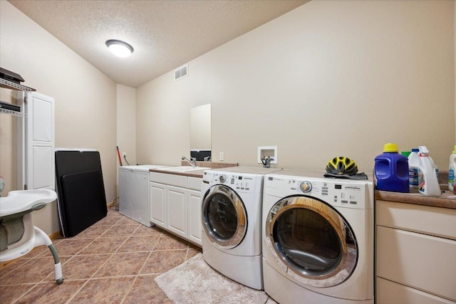 2040 Aster Rd, Spearfish, SD 57783 - laundry area featuring independent washer and dryer, cabinet space, a textured ceiling, and light tile patterned floors