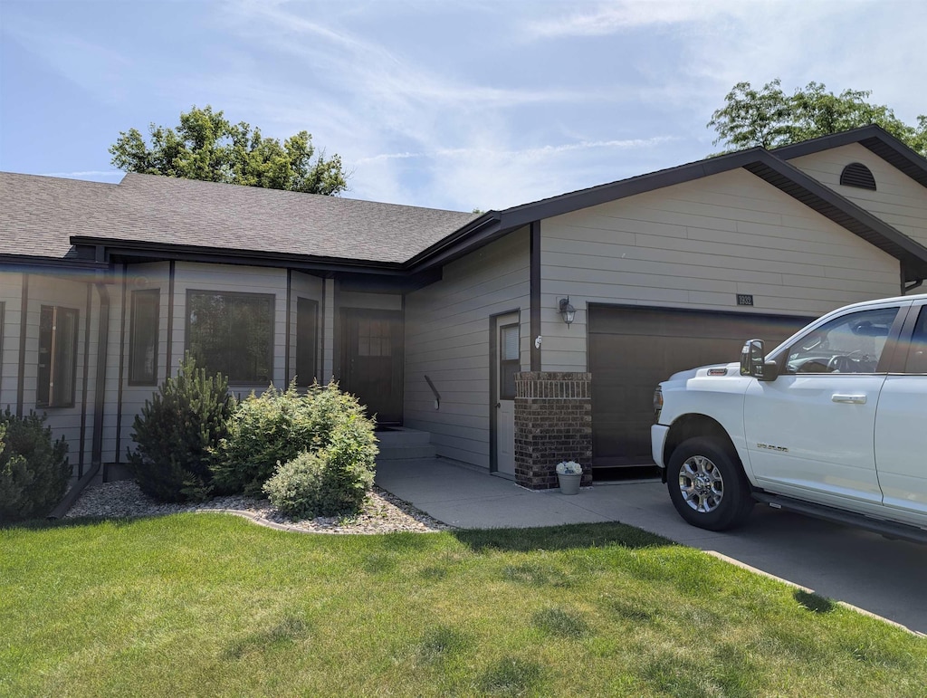 1932 Baldwin St, Sturgis, SD 57785 - view of front of house featuring a garage, a front lawn, and roof with shingles
