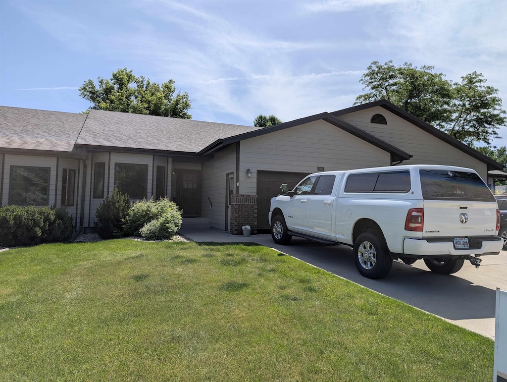 1932 Baldwin St, Sturgis, SD 57785 - ranch-style house with an attached garage, driveway, a front yard, brick siding, and roof with shingles