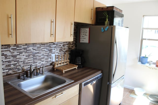 126 E Saint Andrew St, Rapid City, SD 57701 - kitchen featuring light brown cabinets, stainless steel dishwasher, decorative backsplash, and dark countertops