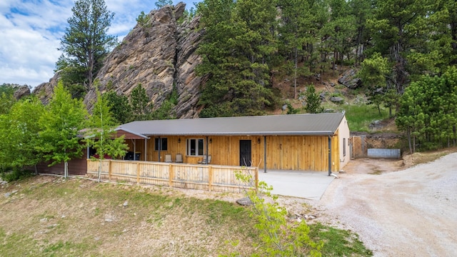 627 W Mt Rushmore Rd, Custer, SD 57730 - view of front of house with driveway, board and batten siding, covered porch, and a metal roof
