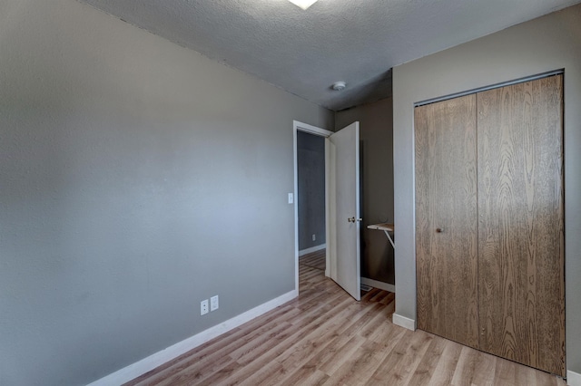 212 E Custer St, Rapid City, SD 57701 - unfurnished bedroom featuring wood finished floors, a closet, and a textured ceiling