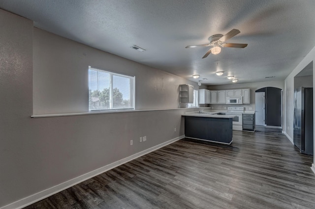 212 E Custer St, Rapid City, SD 57701 - kitchen with white appliances, a peninsula, ceiling fan, arched walkways, and dark wood-type flooring