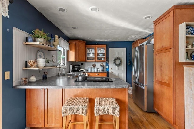 10 Crescent Dr, Deadwood, SD 57732 - kitchen with stainless steel fridge, black electric stovetop, a peninsula, open shelves, and light wood-type flooring