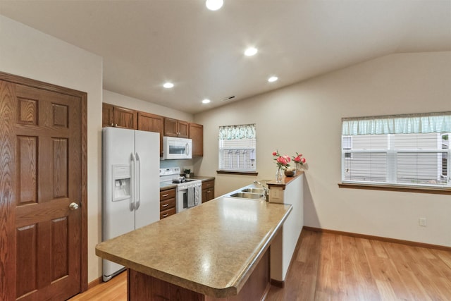 1205 Silverbrook Ln, Spearfish, SD 57783 - kitchen featuring white appliances, light wood finished floors, brown cabinets, a peninsula, and lofted ceiling