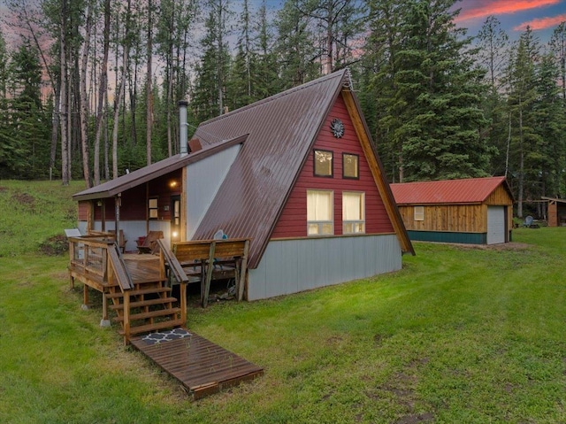 12425 Misty Ln, Nemo, SD 57759 - back of house at dusk featuring a lawn, a deck, a metal roof, and a chimney