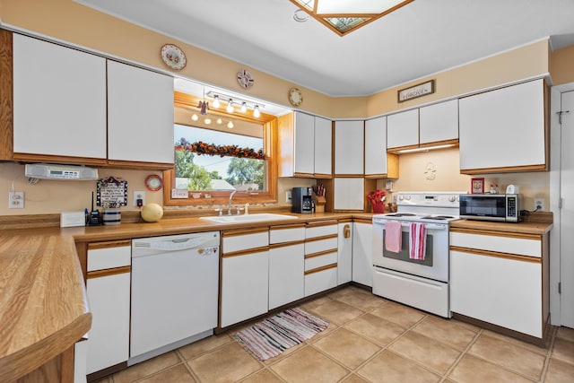 4103 W Main St, Rapid City, SD 57702 - kitchen with white appliances, white cabinets, light countertops, and light tile patterned floors