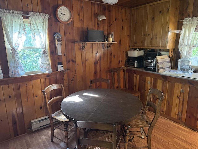 21454 US Highway 85, Lead, SD 57754 - dining area with light wood finished floors, wood walls, and a baseboard heating unit