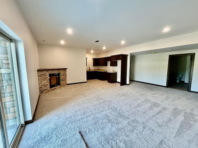 25809 Sidney Trl, Custer, SD 57730 - unfurnished living room with light colored carpet, recessed lighting, a stone fireplace, and plenty of natural light