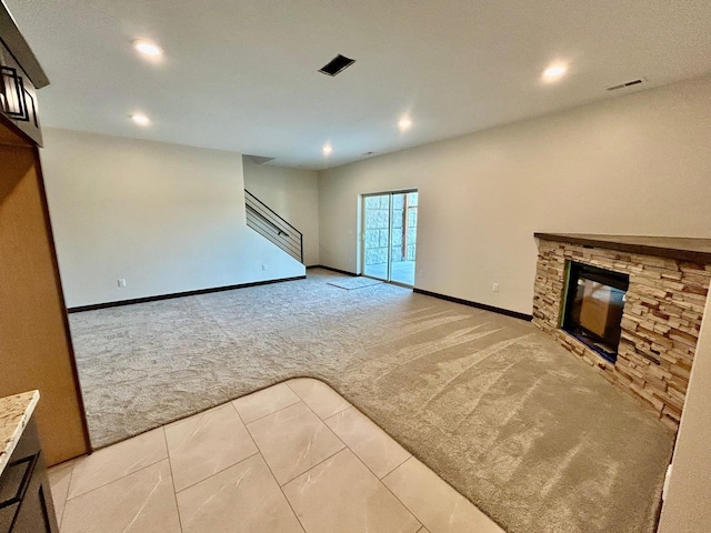 25809 Sidney Trl, Custer, SD 57730 - unfurnished living room featuring light colored carpet, recessed lighting, a stone fireplace, stairway, and light tile patterned floors