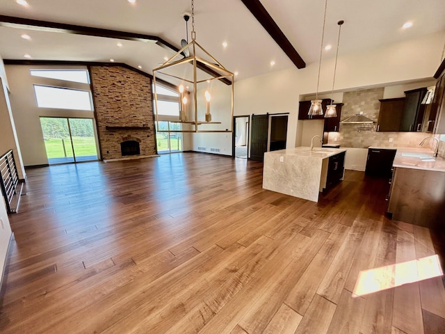 25809 Sidney Trl, Custer, SD 57730 - kitchen with high vaulted ceiling, open floor plan, decorative backsplash, a center island with sink, and a chandelier