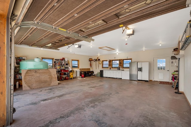 27937 Cascade Springs Rd, Hot Springs, SD 57747 - garage featuring white refrigerator with ice dispenser, stainless steel fridge, a garage door opener, and fridge with ice dispenser