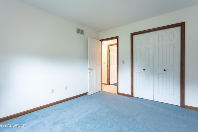 unfurnished bedroom featuring carpet flooring and a closet