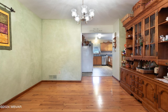 dining room featuring light hardwood / wood-style floors, sink, and a chandelier