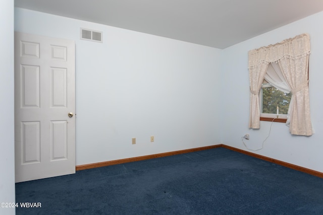 spare room with dark carpet