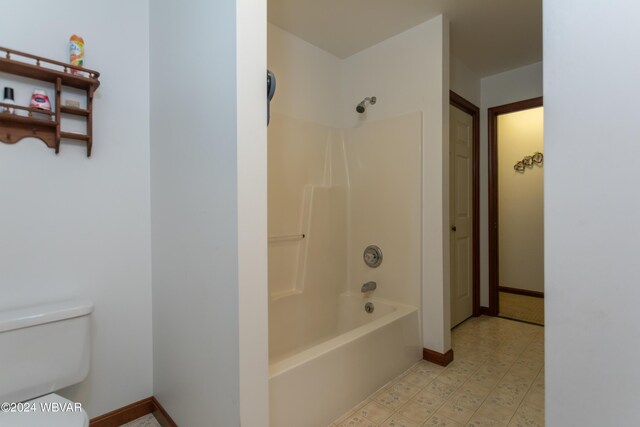 bathroom featuring washtub / shower combination and toilet