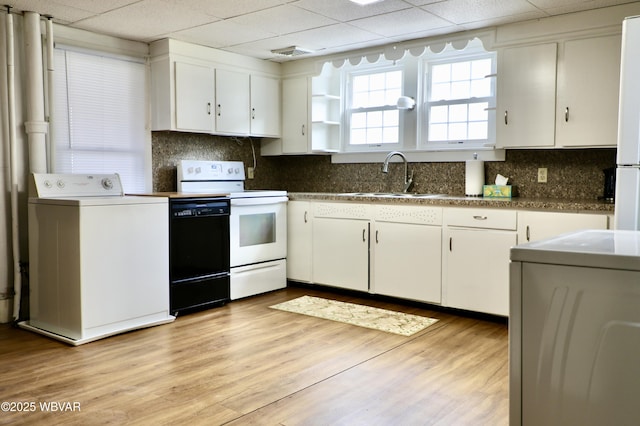 kitchen with washer / dryer, sink, white cabinetry, white electric stove, and light hardwood / wood-style floors