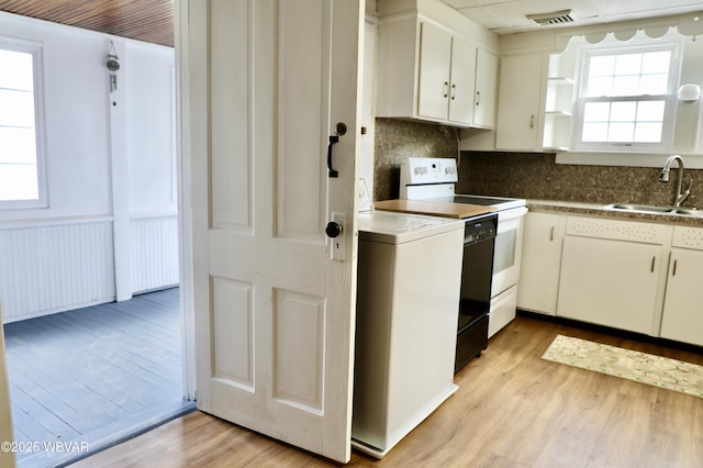 kitchen with a wealth of natural light, sink, white cabinets, white electric range oven, and light wood-type flooring