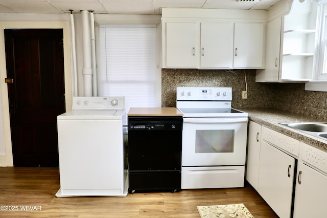 kitchen featuring white range with electric stovetop, washer / clothes dryer, black dishwasher, white cabinets, and light hardwood / wood-style floors