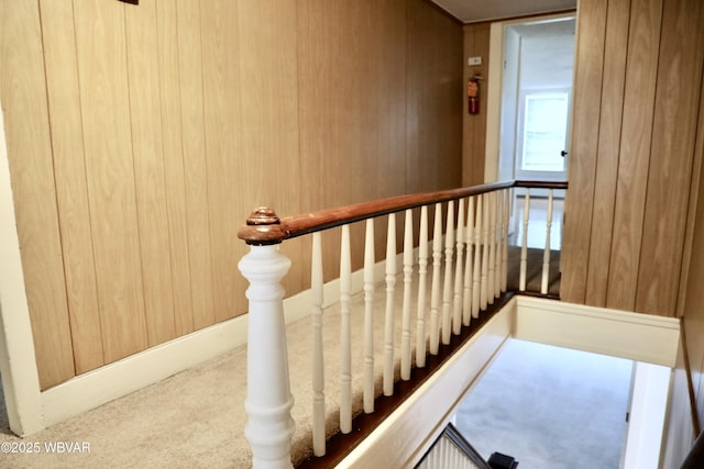 stairway featuring wood walls