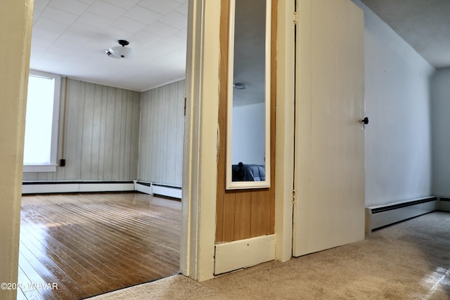 corridor with a baseboard radiator and light hardwood / wood-style flooring