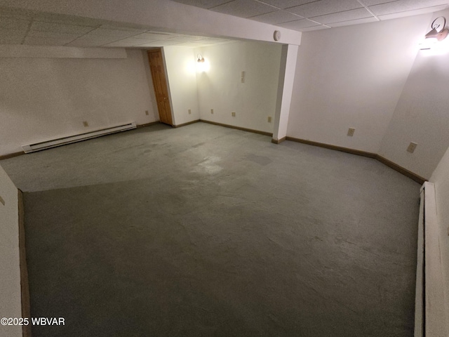 basement with a drop ceiling, light colored carpet, and a baseboard radiator