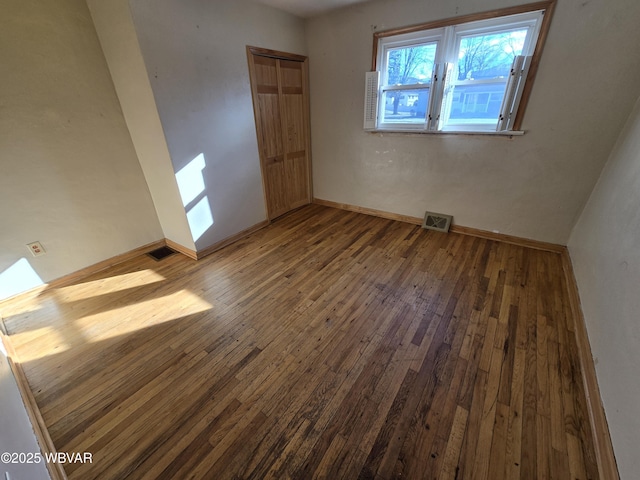 unfurnished room with wood-type flooring