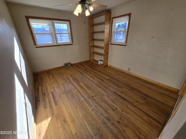 empty room featuring ceiling fan and hardwood / wood-style floors