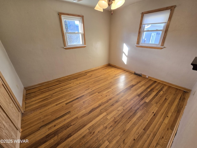 empty room with hardwood / wood-style floors and ceiling fan