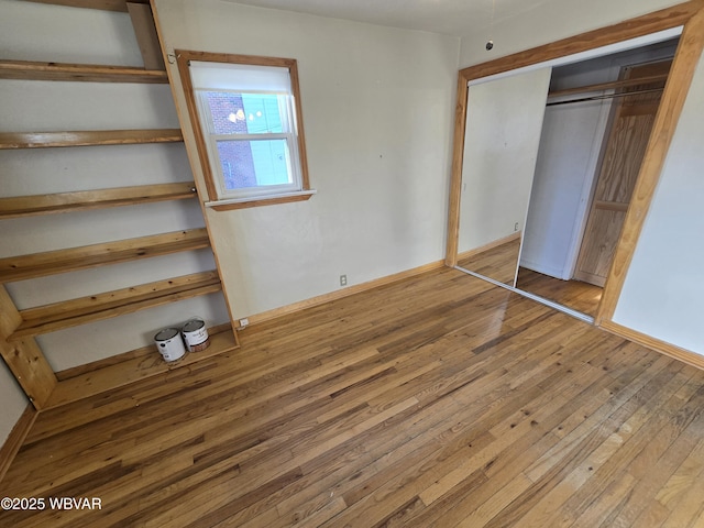 unfurnished bedroom featuring wood-type flooring and a closet