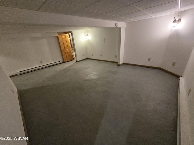 carpeted spare room with a drop ceiling and baseboard heating