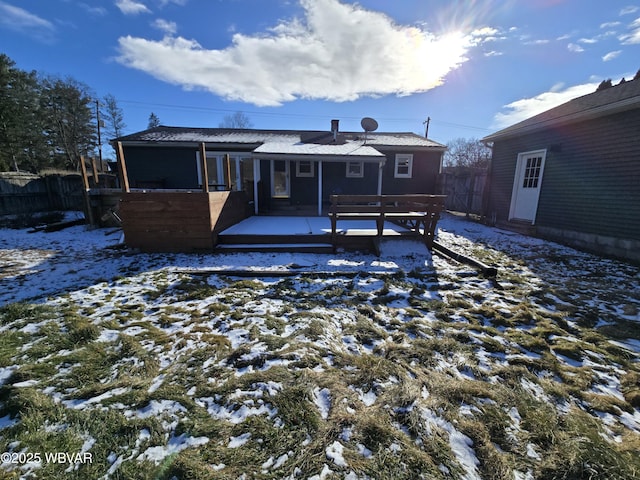 snow covered house featuring a wooden deck