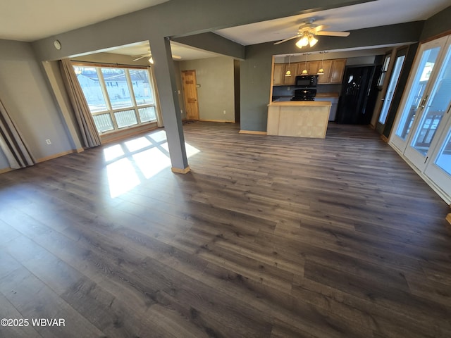 unfurnished living room with dark hardwood / wood-style floors and ceiling fan