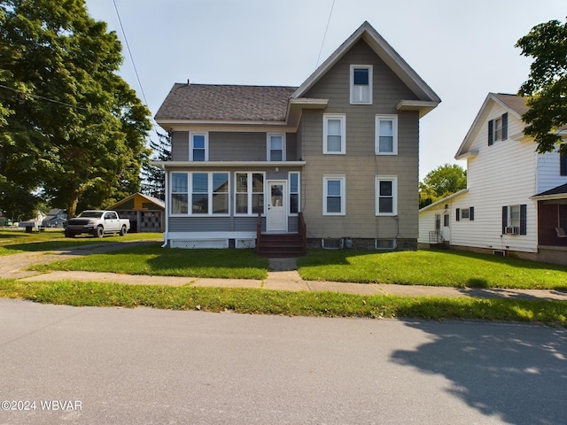 view of front facade featuring a sunroom and a front lawn