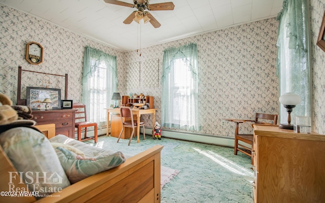 living area with carpet flooring, ornamental molding, ceiling fan, and a healthy amount of sunlight