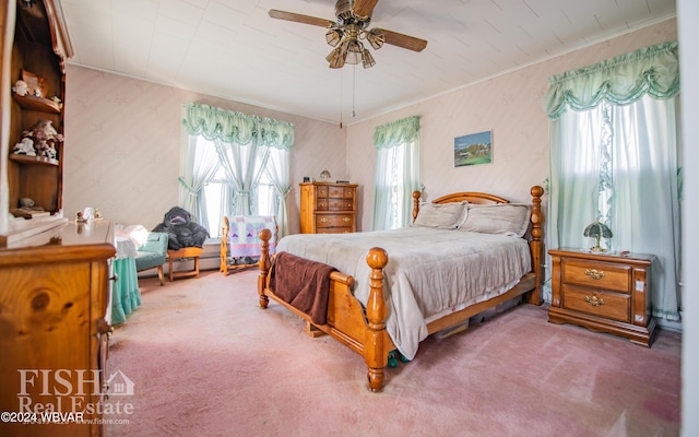 carpeted bedroom featuring multiple windows and ceiling fan