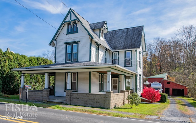 view of front of property featuring an outbuilding, covered porch, and a garage