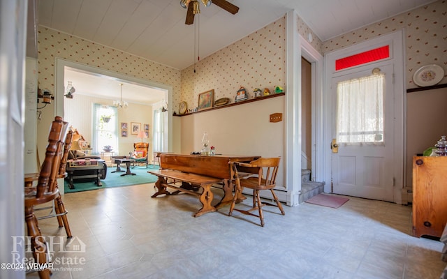 dining room featuring ceiling fan with notable chandelier, a wealth of natural light, and a baseboard heating unit